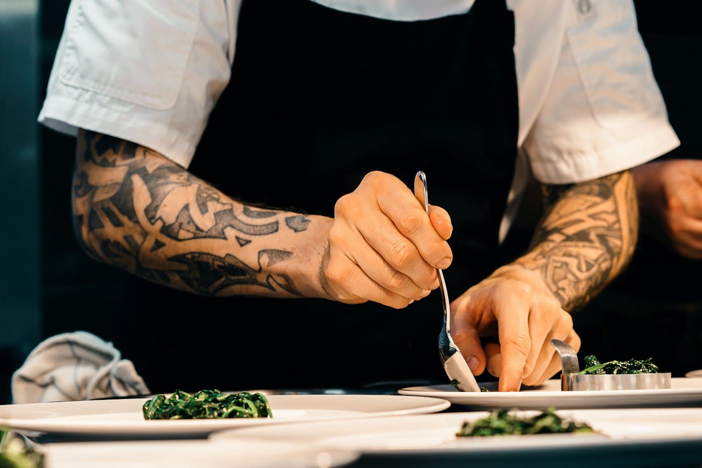 A chef finishing a dish in the kitchen